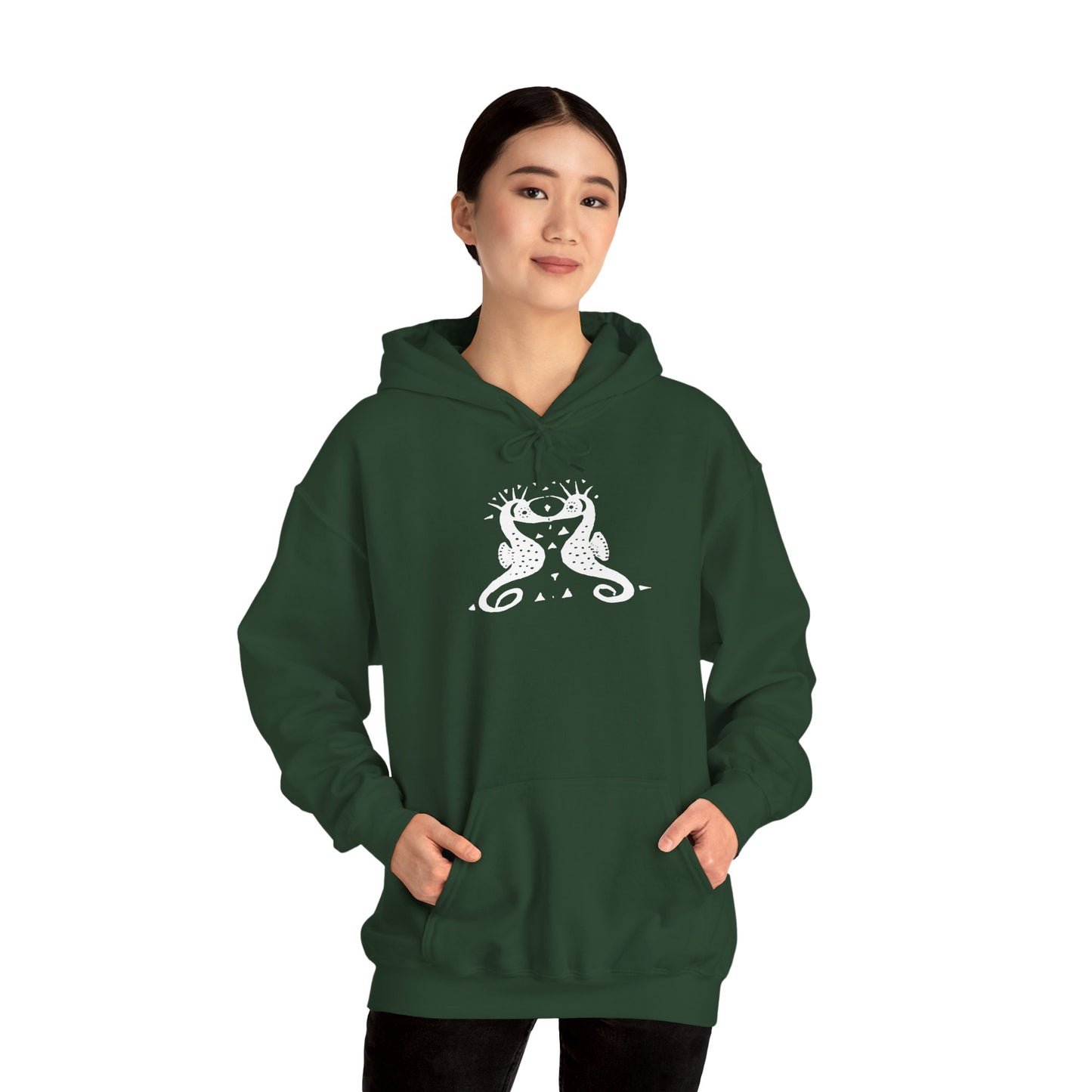 A woman wears a forest green hoodie with a white, art noveau style print of two seahorses facing each other. The seahorses are mirror images of each other.