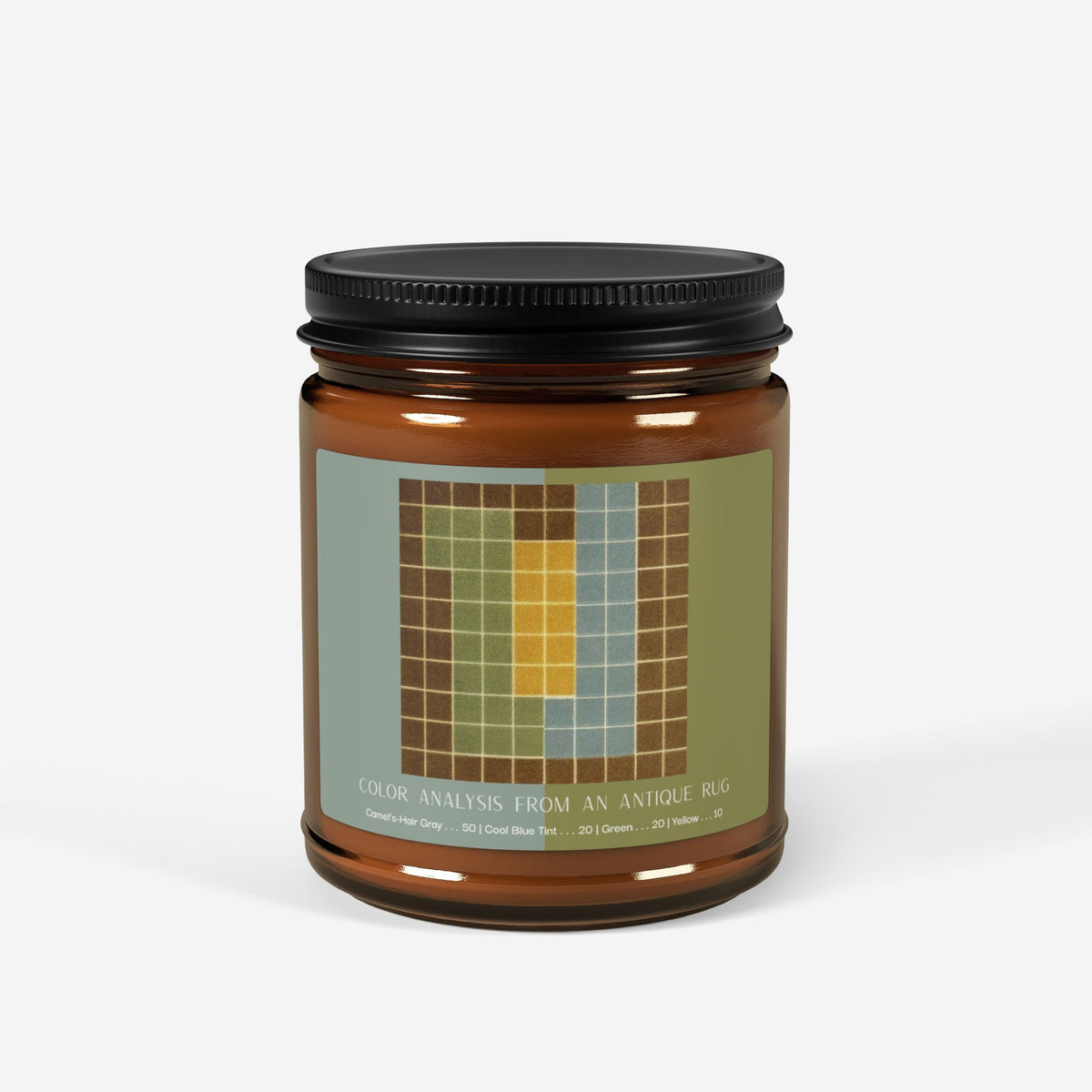 Amber glass candle jar with a black lid and a label showing a ten-by-ten grid with a camel-brown border around columns of sage green, pale blue, and yellow, titled Color Analysis from an Antique Rug.