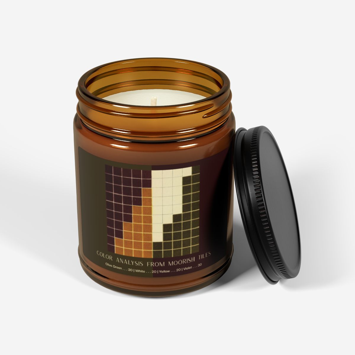 Amber glass candle jar with a black lid and a label showing a ten-by-ten grid of violet, golden yellow, cream, and olive green squares, titled Color Analysis from Moorish Tiles.